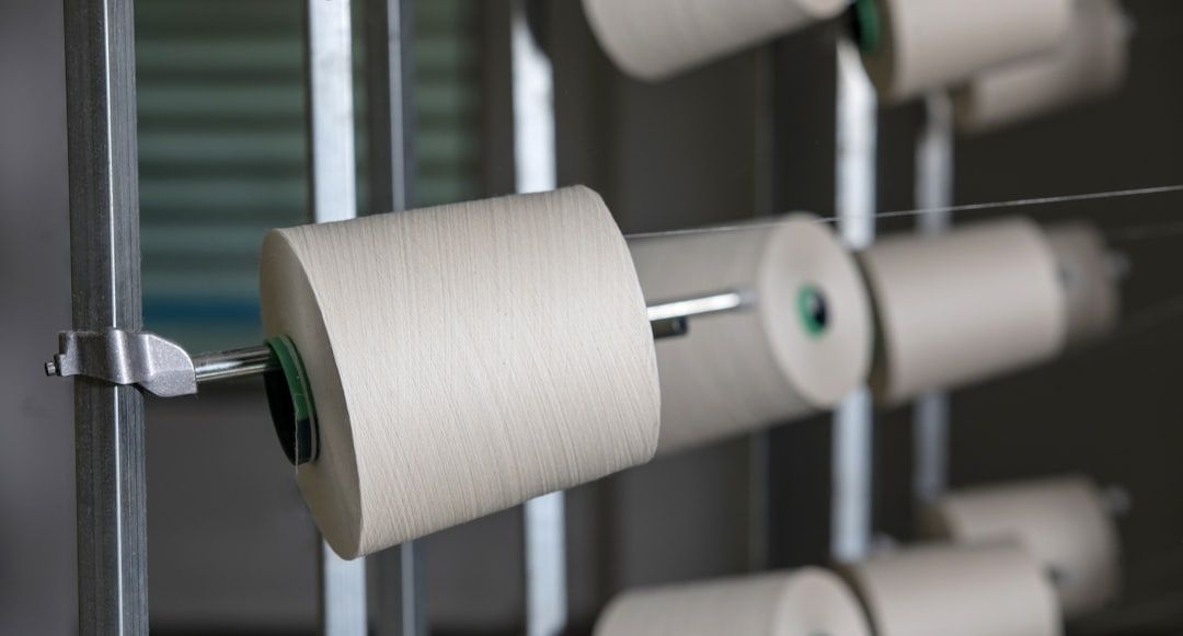 Aufgespulte textile Fäden auf mehreren Spulen in einer Fertigungsanlage