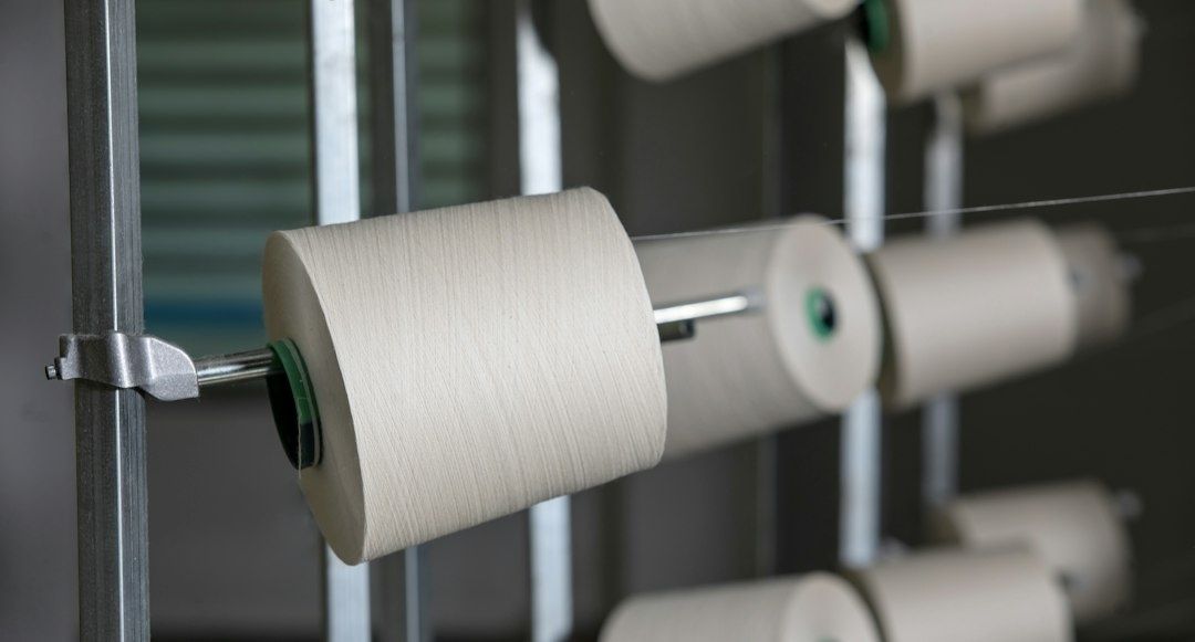 Weiße Garnspulen auf einer industriellen Spinnvorrichtung