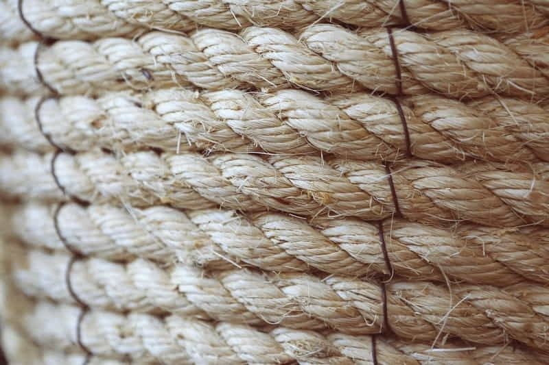 Nahaufnahme grober, naturfarbener Bastfasern mit dunklen Nähten